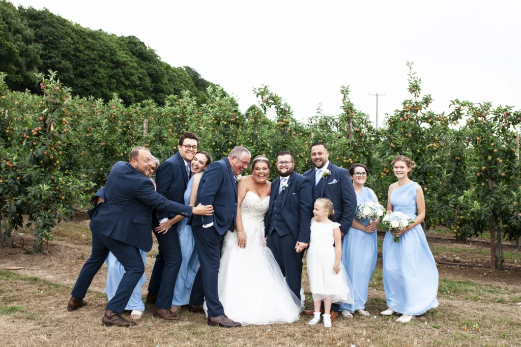 Breathtaking Kent wedding photography featuring the bride and grooms family surrounded by stunning natural beauty at the barnyard venue."